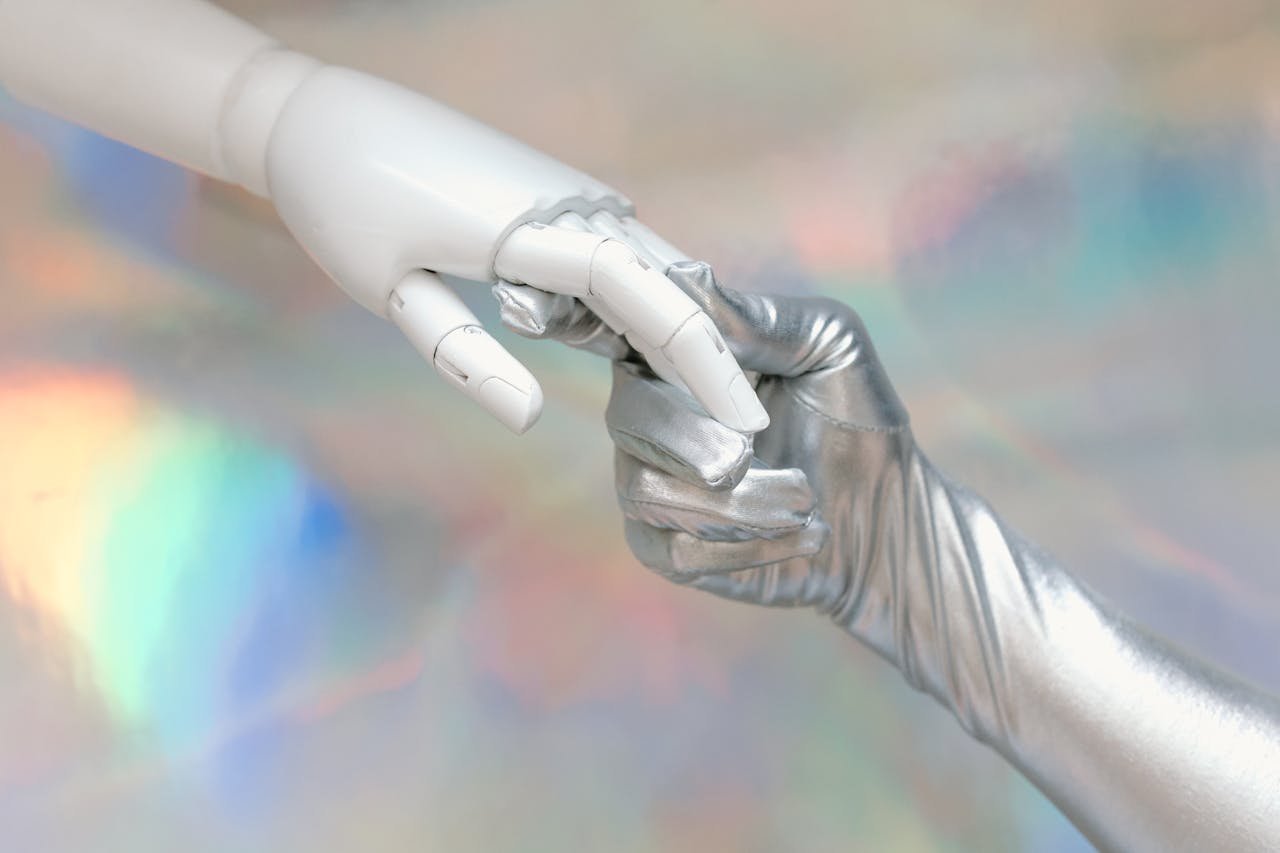 Close-up of a robot hand and silver-gloved hand touching, symbolizing human-robot connection.